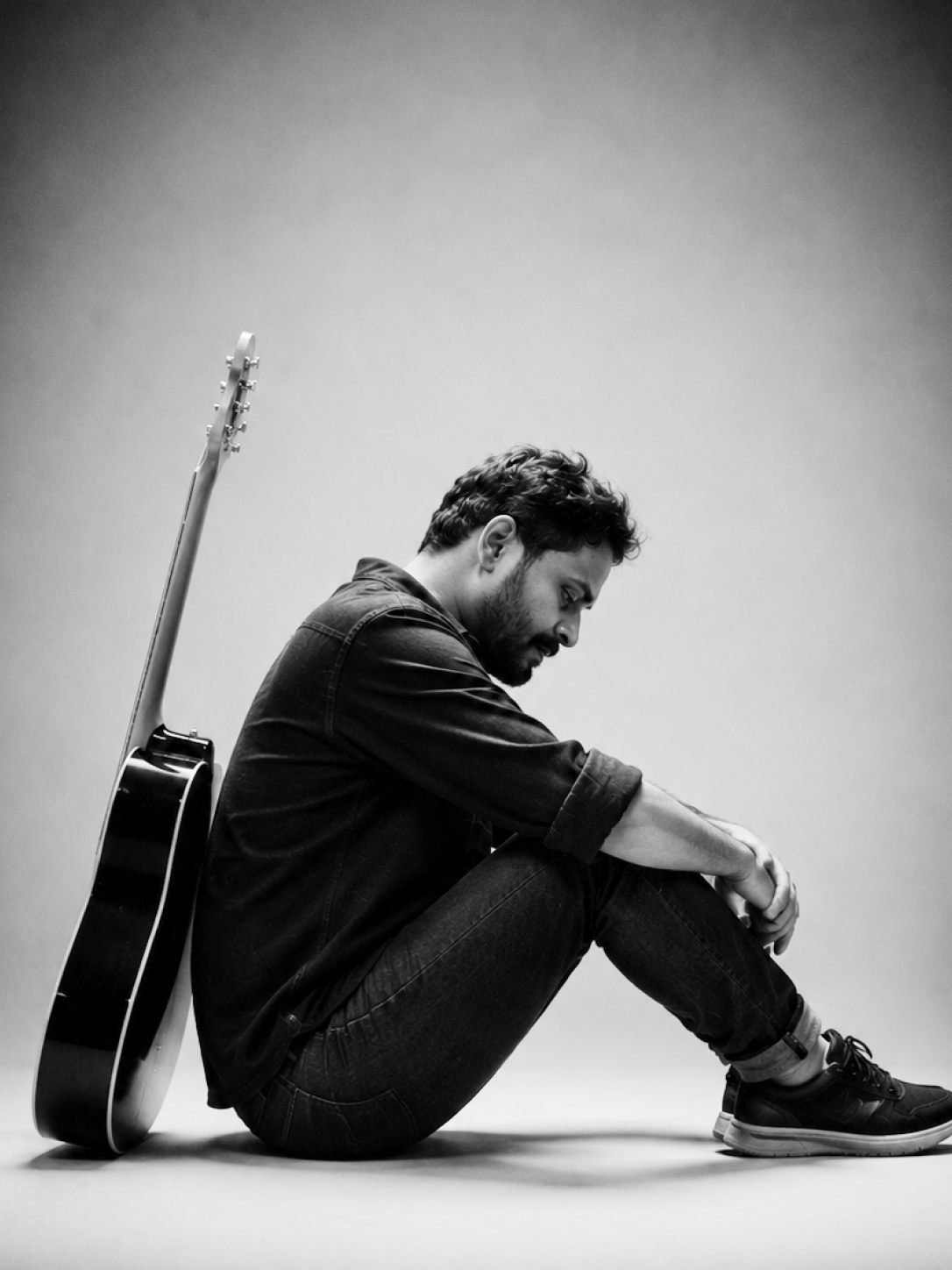 Sai Kiran sitting with his acoustic guitar