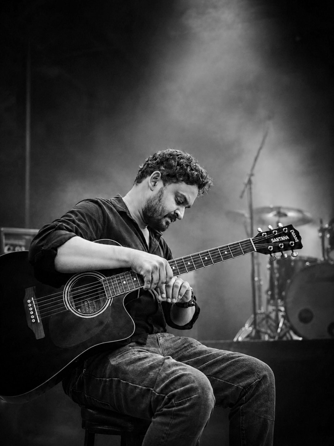 Sai Kiran playing acoustic guitar on stage